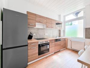 eine Küche mit Holzschränken und einem großen Fenster in der Unterkunft RAJ Living - 3 and 4 Room Apartments in Duisburg