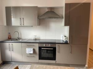 a kitchen with white cabinets and a sink and an oven at SplendideT4#6lits#3 chambres# Geneve/Paris/Gare in Bellegarde-sur-Valserine