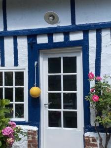 una casa azul y blanca con una puerta blanca y azul en La Petite Fanny, en Étretat