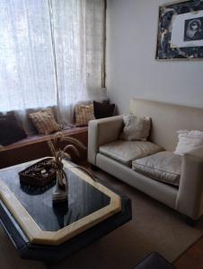 uma sala de estar com um sofá e uma mesa de centro em CASA ANGELITA en SAAVEDRA em Buenos Aires