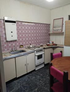 a kitchen with a stove and a sink and a table at CASA ANGELITA en SAAVEDRA in Buenos Aires