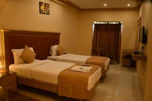 מיטה או מיטות בחדר ב-Bairav Grand Madurai
