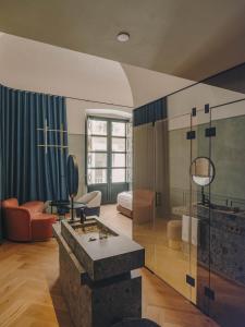 a living room with a fireplace and a room with a couch at Hotel Palau Fugit in Girona