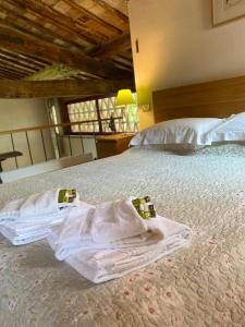 a bedroom with two white towels on a bed at Il Capanno in Asciano