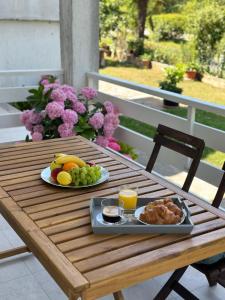 una mesa de madera con una bandeja de fruta y zumo en Iris apartment, en Vižinada