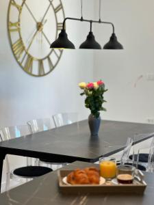 a table with a plate of pastries and a clock at Iris apartment in Vižinada