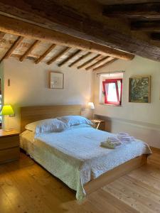 a bedroom with a bed with a blue comforter and a window at Il Capanno in Asciano