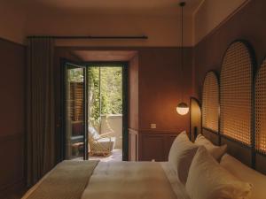 a bedroom with a large bed with a large window at Hotel Palau Fugit in Girona