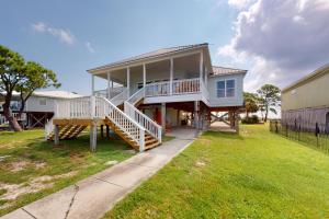 a large house with a large porch and stairs at Sunset Bay in Dauphin Island
