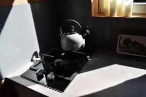a tea kettle sitting on top of a stove at La cabane aux écureuils in Philippeville