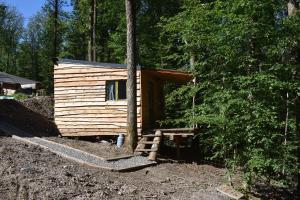 una cabaña de madera en medio de un bosque en La cabane aux écureuils en Philippeville