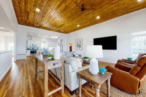 a living room with white walls and a wooden ceiling at Sunset Bay in Dauphin Island