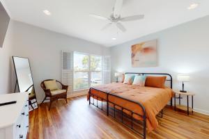 a bedroom with a bed and a desk and a window at Sunset Bay in Dauphin Island