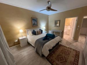a bedroom with a bed and a ceiling fan at Beach front Rocky Pools in Bettyʼs Bay