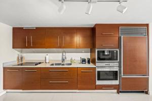 a kitchen with wooden cabinets and stainless steel appliances at Iconbrickell in Miami