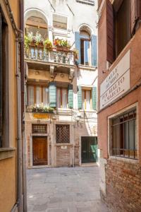 an alley in a city with a building with flowerpots at Campiello Zen B&B in Venice