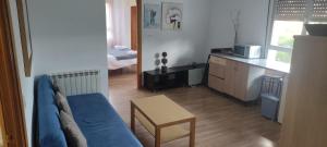 ein Wohnzimmer mit einem blauen Sofa und einem Tisch in der Unterkunft Apartamentos El Cruce in Villafranca del Bierzo