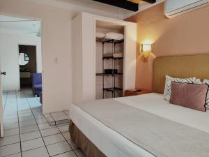 a bedroom with a bed and a living room at Hotel Tropicus Boutique in Puerto Vallarta