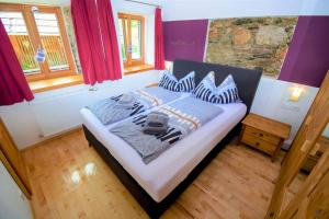 a bedroom with a large bed with purple walls at David Appartments in Mauterndorf