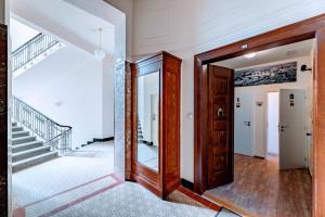 um corredor de uma casa com uma escada e um espelho em Black & White Flat for 2 / Peaceful / Jewish Quarter em Praga