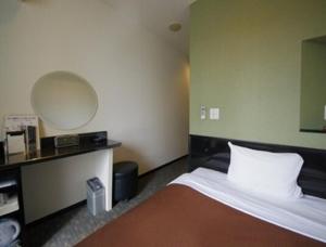 a hotel room with a bed and a mirror at Urbain Hiroshima Executive in Hiroshima