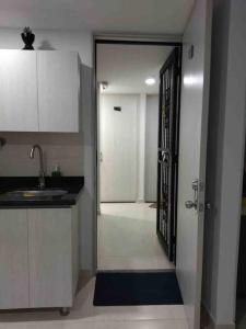 a kitchen with a door leading to a hallway at Apartamento nuevo, próximo al metro y CC Mayorca in Sabaneta