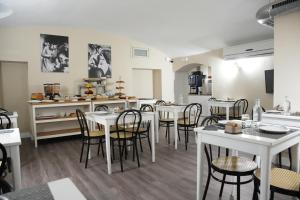 un comedor con mesas y sillas blancas en Hotel Montevecchio, en Turín