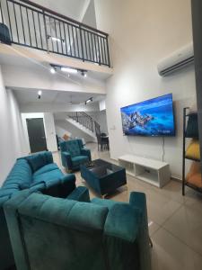 uma sala de estar com um sofá azul e uma televisão de ecrã plano em Metropol Serviced Apartment em Bukit Mertajam