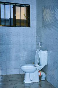 a white toilet in a room with a window at Ariel comfort home in Arusha