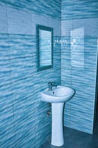 een badkamer met een witte wastafel en een spiegel bij Ariel comfort home in Arusha