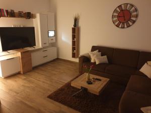 uma sala de estar com um sofá e um relógio na parede em FeWo - Zur Alten Wäscherei - Zentrumsnah - Garage inklusiv em Estugarda