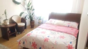 1 dormitorio con 1 cama con edredón rosa y blanco en Topolowa 13, en Mińsk Mazowiecki