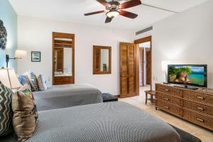 a bedroom with two beds and a flat screen tv at Mauna Lani Terrace J101 in Waikoloa