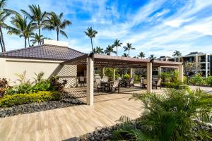 an outdoor deck with a gazebo and palm trees at Mauna Lani Terrace J101 in Waikoloa