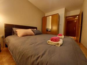 a bedroom with a large bed with towels on it at Venus Apartman in Brčko
