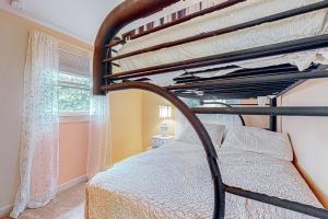 a bedroom with two bunk beds and a window at Crystal Lake Cottage in Alton Bay