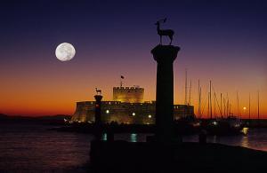 a statue of a deer on a column in front of a castle at Muses-Old Town in Rhodes Town