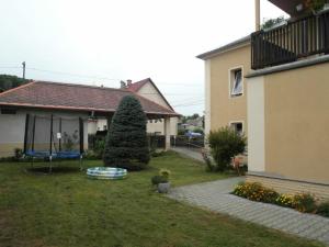 une cour avec une maison et un arbre dans l'herbe dans l'établissement Pokoje s vlastní koupelnou a WC, à Doksy