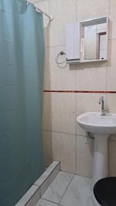 y baño con lavabo, aseo y ducha. en Departamento WISCZOREK en Puerto Iguazú