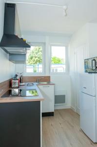 a kitchen with a sink and a white refrigerator at Appartement Proche Gare Routière in Fougères