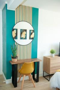 a room with a table and a mirror and a chair at Appartement Proche Gare Routière in Fougères