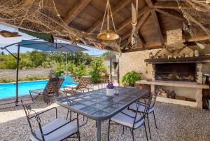 a patio with a table and chairs and a fireplace at Apartments Bugenvila Brzac in Brzac
