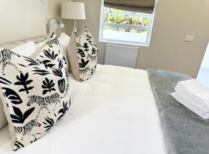 a bedroom with a bed with black and white pillows at Adrift Guesthouse St Francis Bay in St Francis Bay