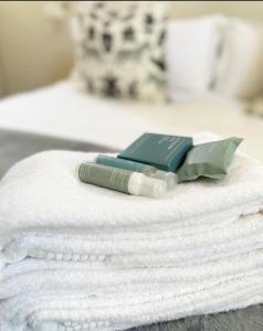 a pile of towels with a book on top of them at Adrift Guesthouse St Francis Bay in St Francis Bay