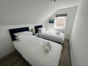 two twin beds in a room with a window at Seacliff, Broad Haven. in Broad Haven