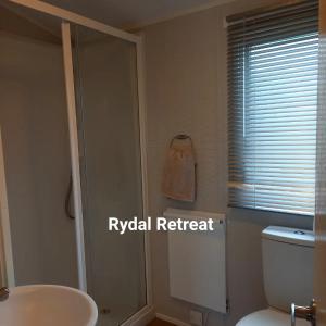 a bathroom with a white toilet and a sink at Rydal Retreat Lakeland Holiday Park in Flookburgh