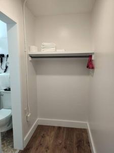 a white bathroom with a toilet and a shelf at Serene Studio Apt in Gadsden AL in Gadsden