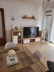 una sala de estar con un televisor y una mesa en Virgen de los desamparados, en Puerto Sagunto