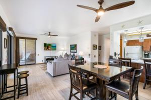 a dining room and living room with a table and chairs at The Shores at Waikoloa 114 in Waikoloa