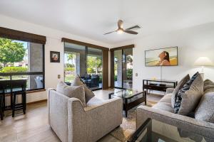 a living room with two couches and a table at The Shores at Waikoloa 114 in Waikoloa